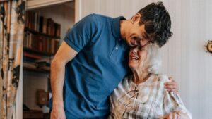 A son and his mother share a laugh together at home.