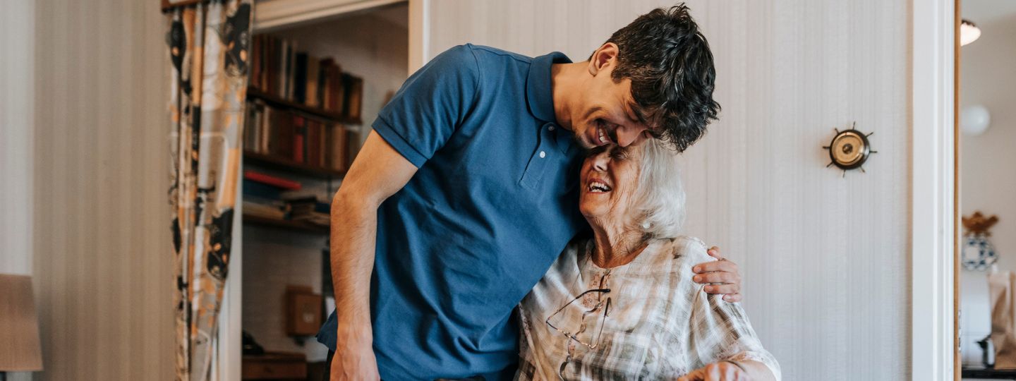A son and his mother share a laugh together at home.